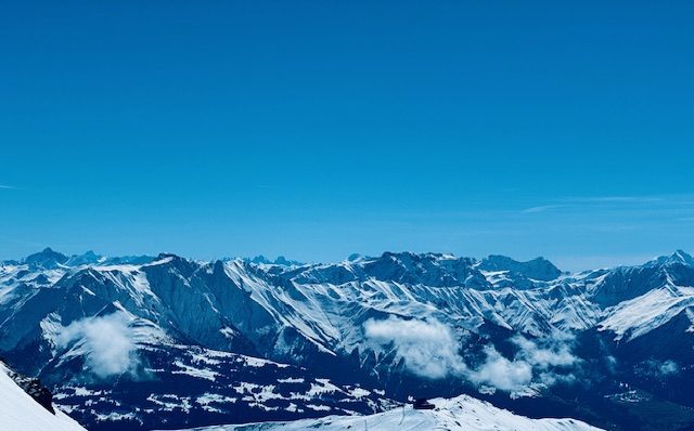 Verschneites Alpenpanorama unter blauem Himmel