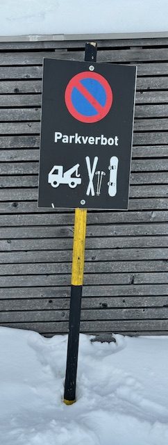 Parkverbot-Schild für Skier und Snowboards im Schnee